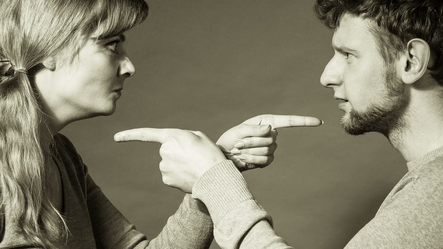Man and woman pointing fingers at each other