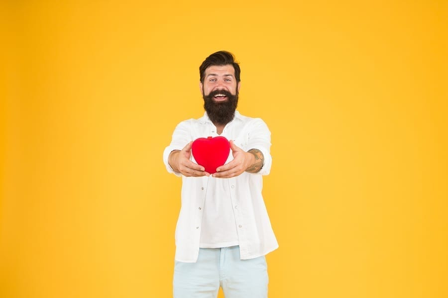 Love you. Being honest. Romantic guy with red heart toy. Romance concept. Celebrate valentines day. Romantic hipster sharing love. Spread love around. Generous lover. Love symbol. From sincere heart.